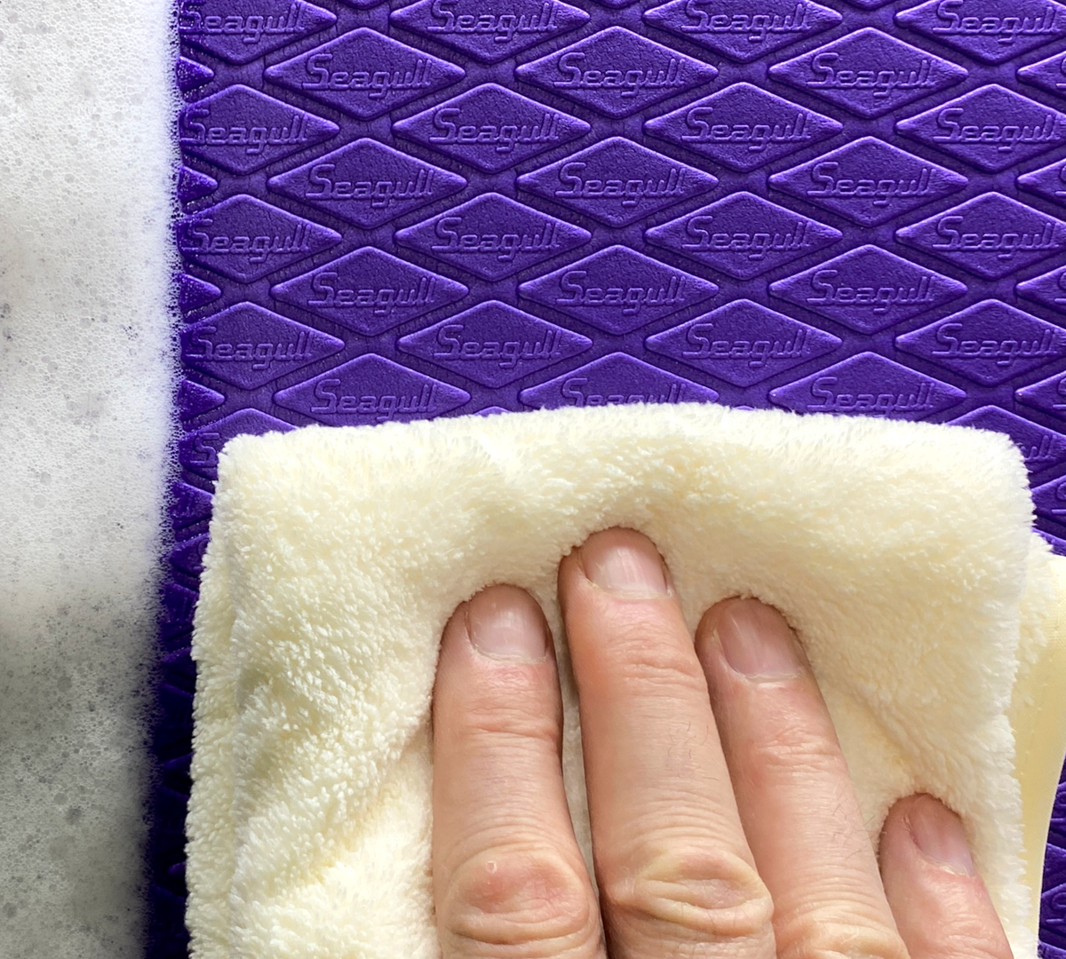Seagull EVA dog grooming mat being wiped clean, showing its easy-clean textured surface