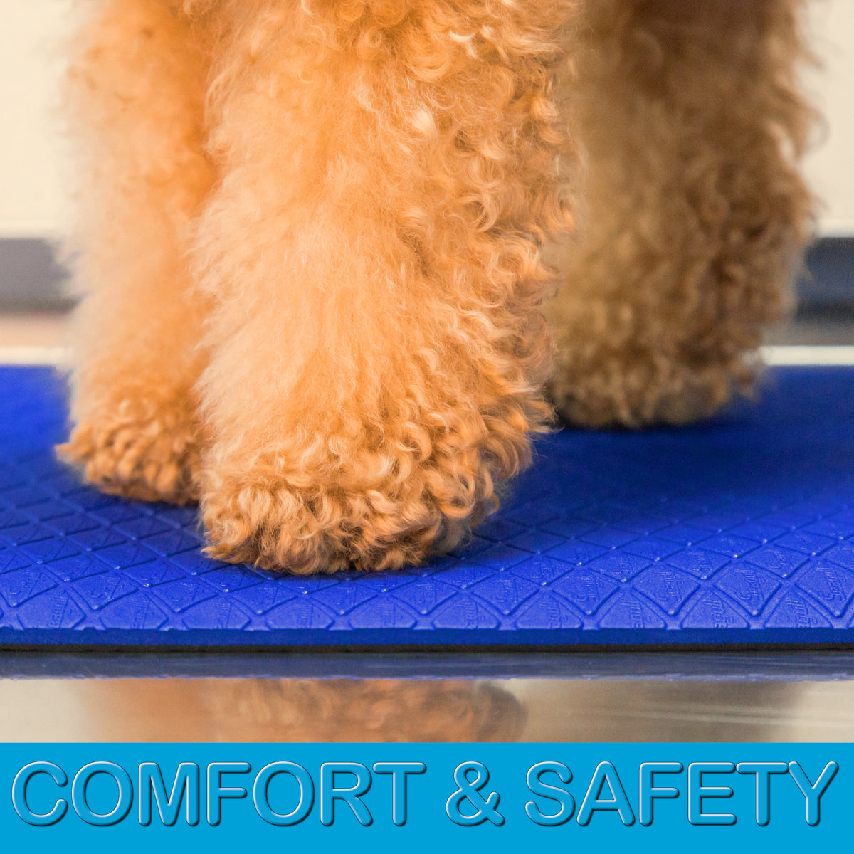 Soft cushioned dark blue grooming mat with non-slip textured backing on a stainless steel grooming table