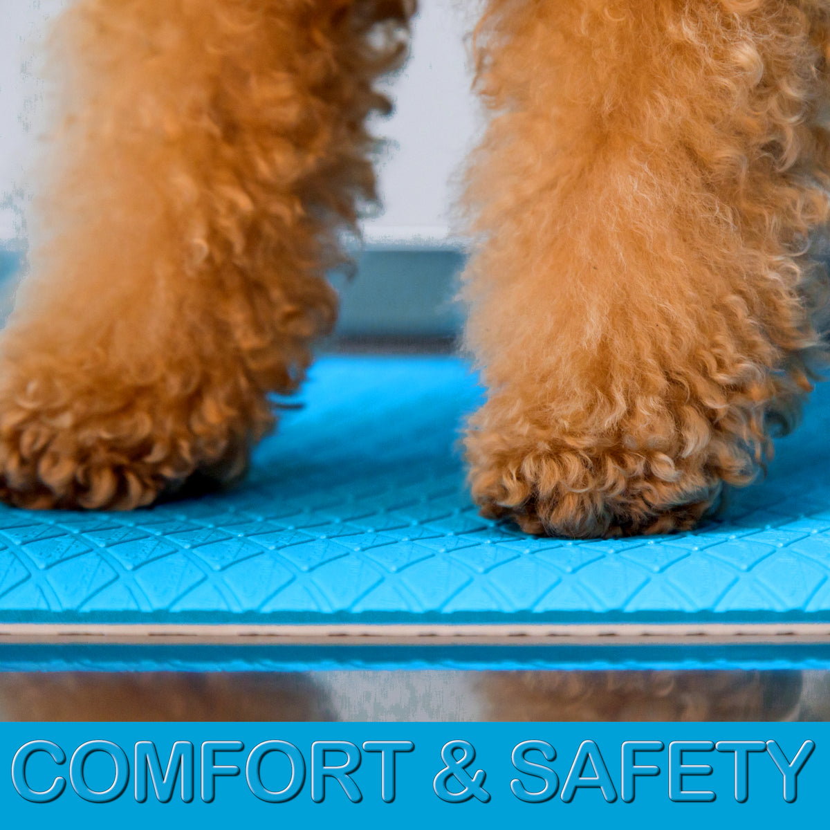 Soft cushioned light blue grooming mat with non-slip textured backing on a stainless steel grooming table