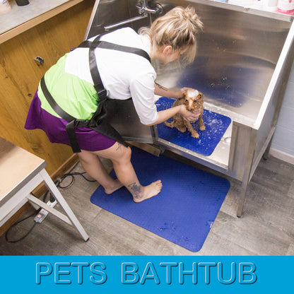 Dark blue non-slip grooming mats used in a pet bathtub and under a groomer’s feet for safer, more comfortable grooming